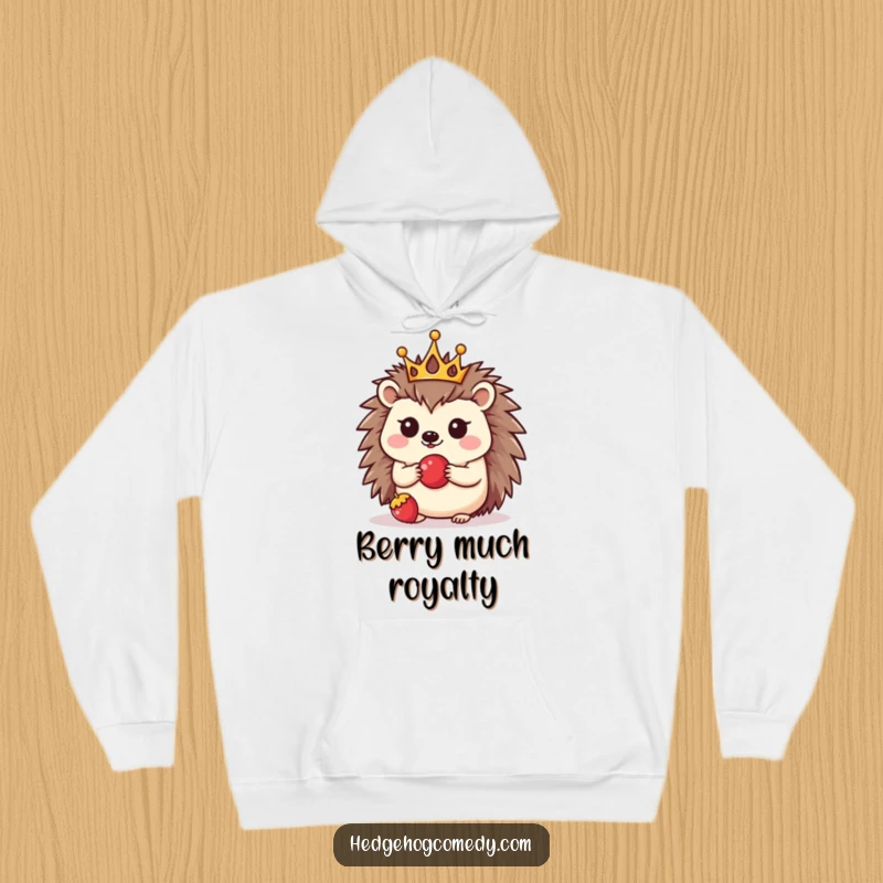 Funny hoodie depicting a tiny crowned kawaii hedgehog balancing a berry, perfect for anyone who loves cute and funny animal designs.