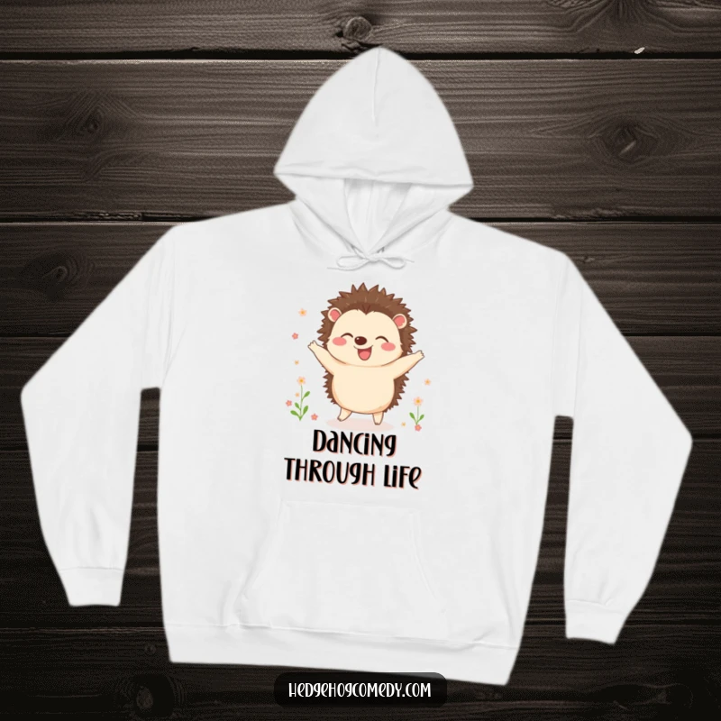 Funny hoodie featuring a joyful hedgehog dancing happily surrounded by tiny, blooming flowers, bringing warmth and cheerful vibes.