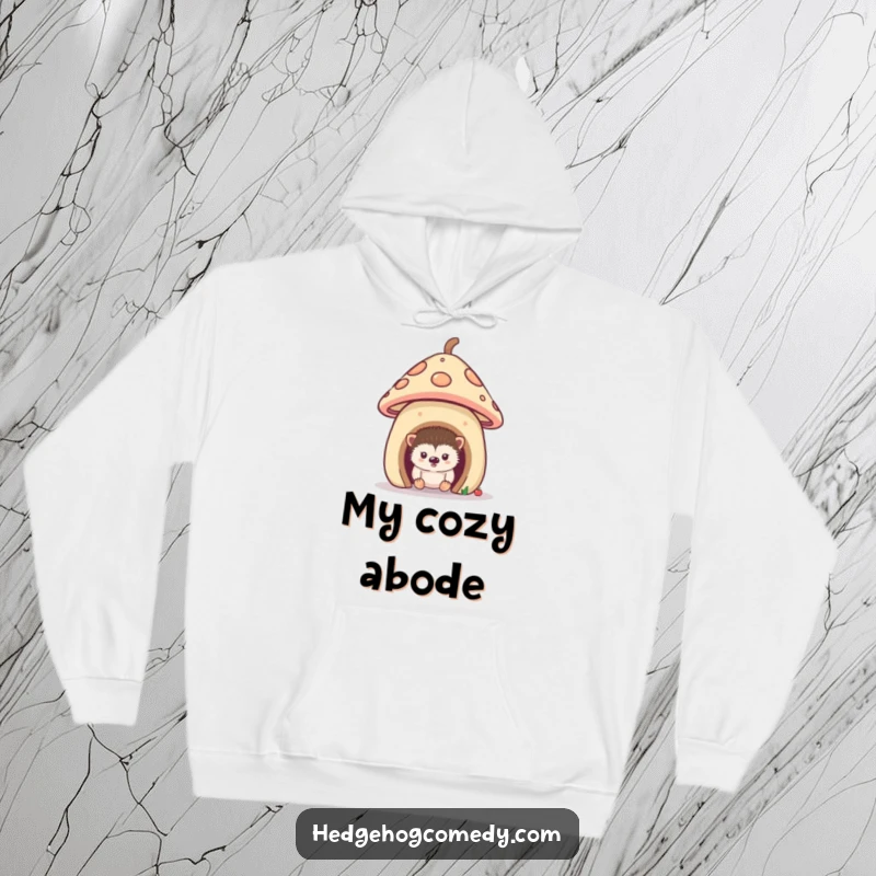 Funny hoodie featuring a curious hedgehog peeking from its adorable mushroom house, offering warmth and a sense of cozy mystery.